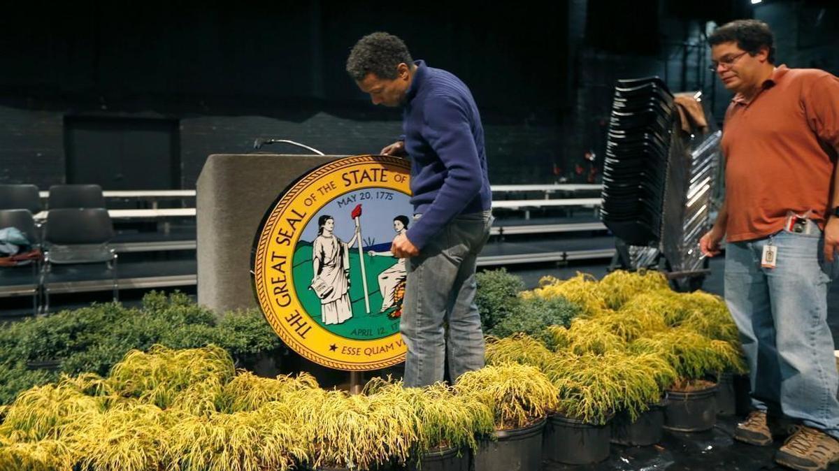 Jeff Lackey, left, and Miguel Santiago, right, with the North Carolina Department of Transportation, set up the state seal as they help prepare Memorial Auditorium at the Duke Energy Center Thursday, Jan. 5, 2017, for Gov. Roy Cooper's swearing-in ceremony on Saturday.
