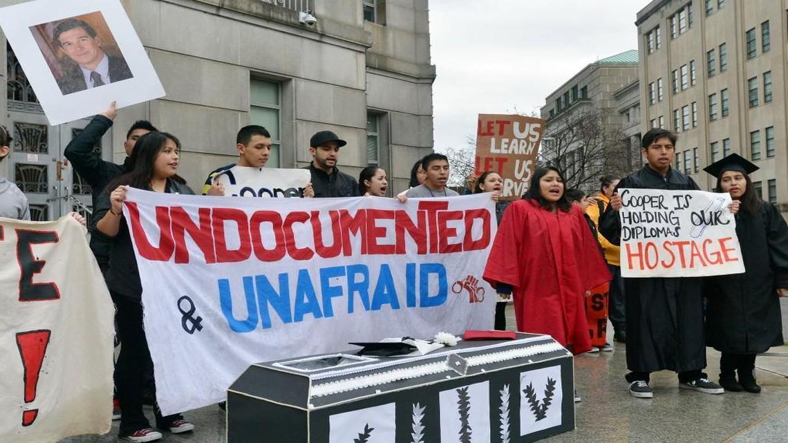 
Immigration activists chant behind a cardboard coffin on the front steps of the Attorney General's office at in 2014. Legislation approved in the state Senate would ban local governments from refusing to enforce immigration laws.
