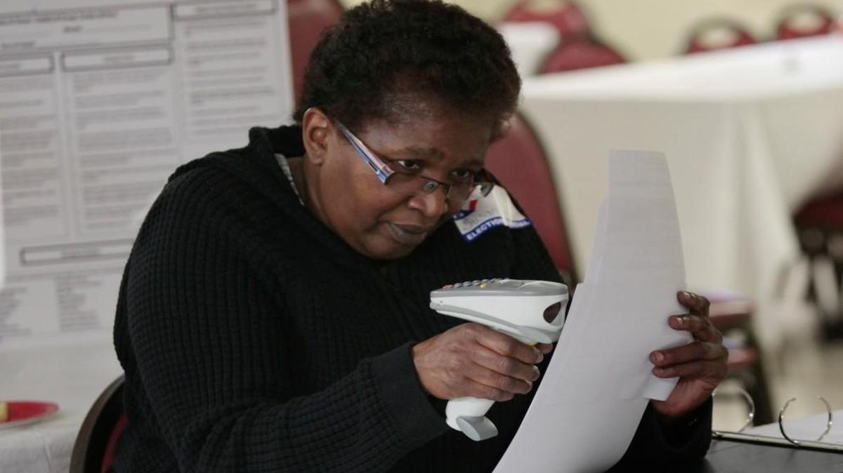 Chapel Hill Northside precinct poll worker Susan Headen scans the bar codes on a ballot so it will match up with a voter ID during a primary election on May 6, 2014.