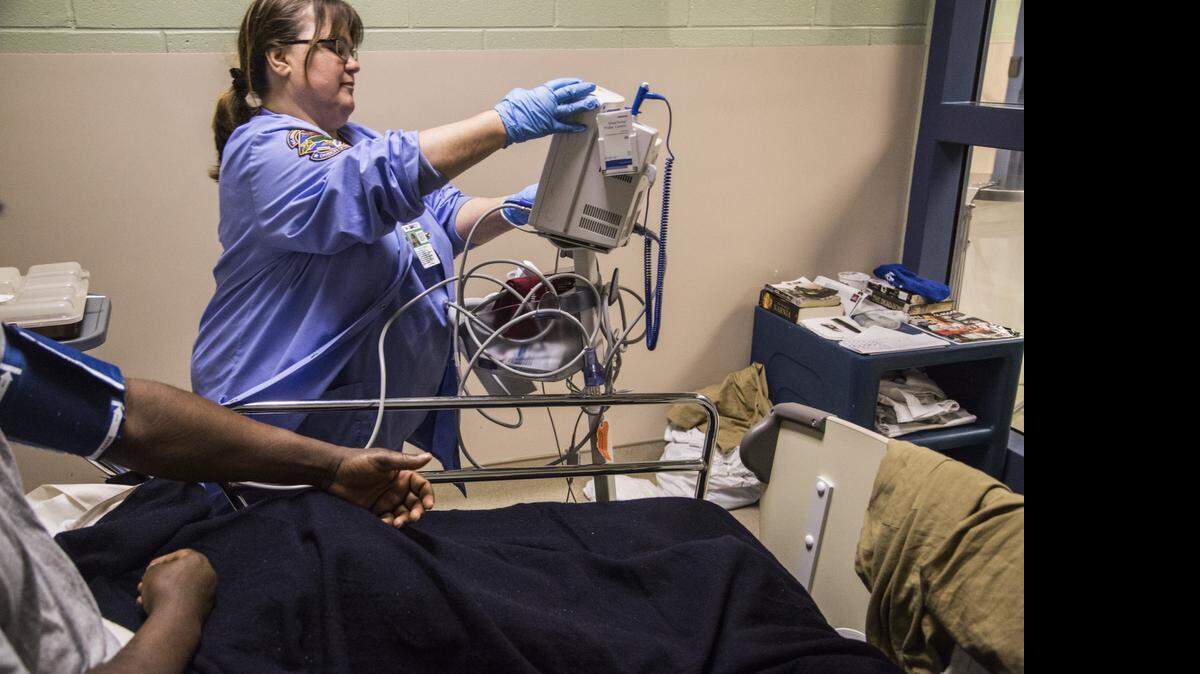 
Contract nurse Kathy Scott tends to a prisoner Thursday, April 16, 2015 at North Carolina Central Prison Regional Medical Center and Mental Health Facility. 