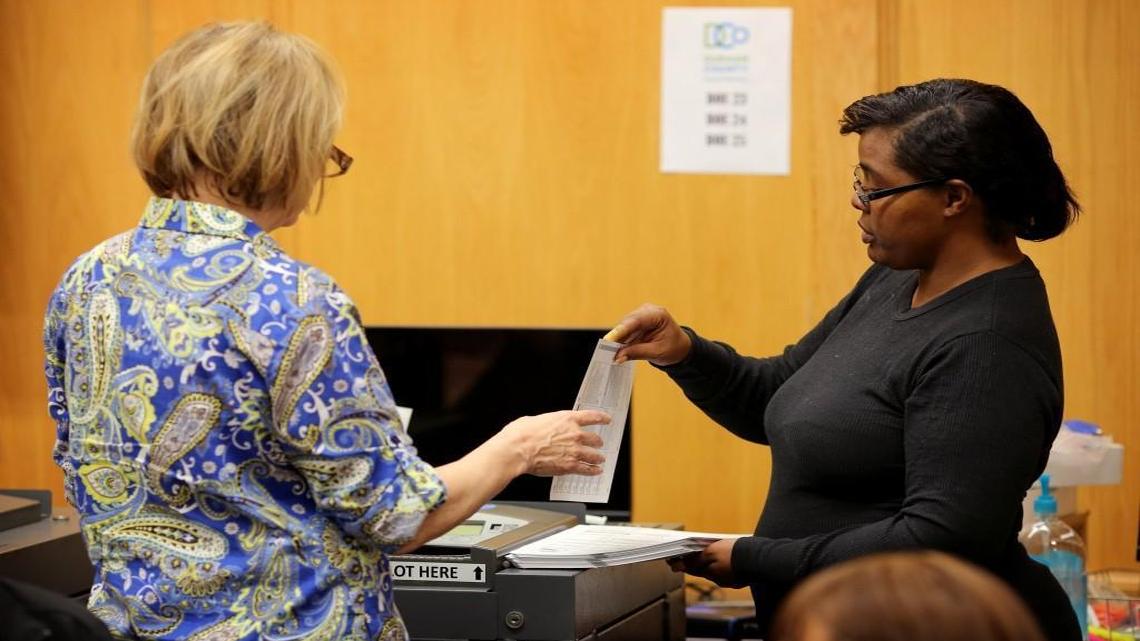 Paid volunteers process ballots during the second day of a Durham County vote recount at the Durham County Board of Elections on Sunday, Dec. 4, 2016.