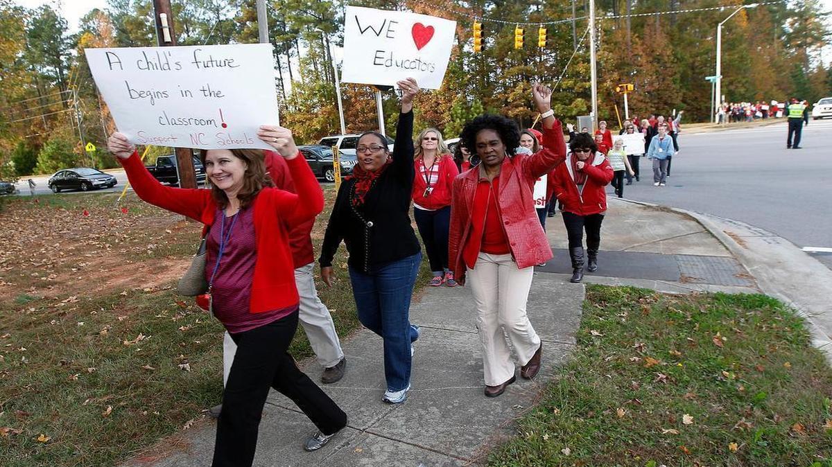 
Teachers, students and other protestors march from Middle Creek HS to West Lake Middle School in Apex on Nov. 4, 2013. Protestors wore red and held signs as part of a statewide network of teacher walk-ins. On Tuesday, June 5, 2015, a divided NC Appeals Court said lawmakers' attempt to end teacher tenure was unconstitutional.
