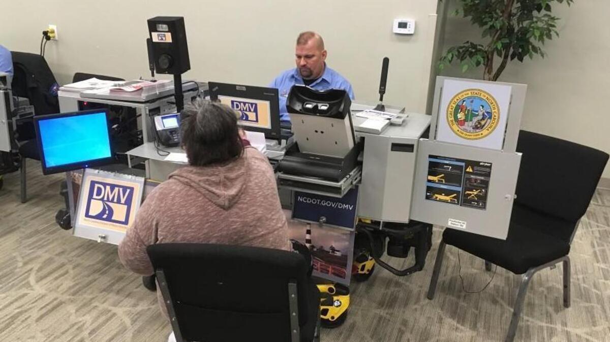 N.C. Division of Motor Vehicles driver’s license examiner Daniel Johnson helps a customer at one of two mobile workstations that visit the Renaissance Centre in Wake Forest on the first and third Monday of every month.