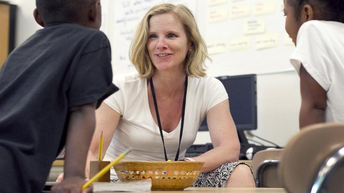 
Jane Gilewicz, a teacher's assistant at Poe Elementary School in Raleigh, works with Yasemire Brailsford (left) and Lesly Salinas Noyola in a K-1 class in 2014. The Senate’s budget proposal would cut funding for teacher’s assistants.
