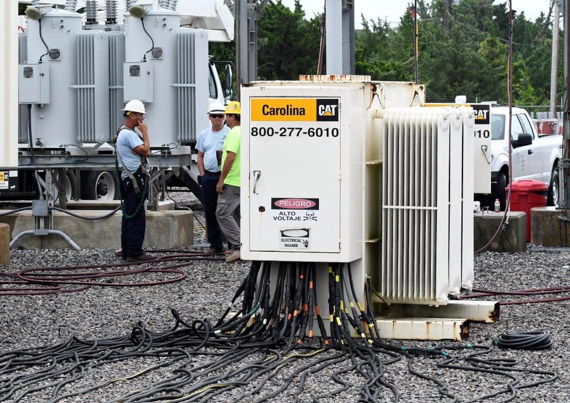 Cape Hatteras Electric Cooperative workmen keep watch on generators at the Avpn substation on Hatteras Island in North Carolina, Saturday, July 29, 2017.