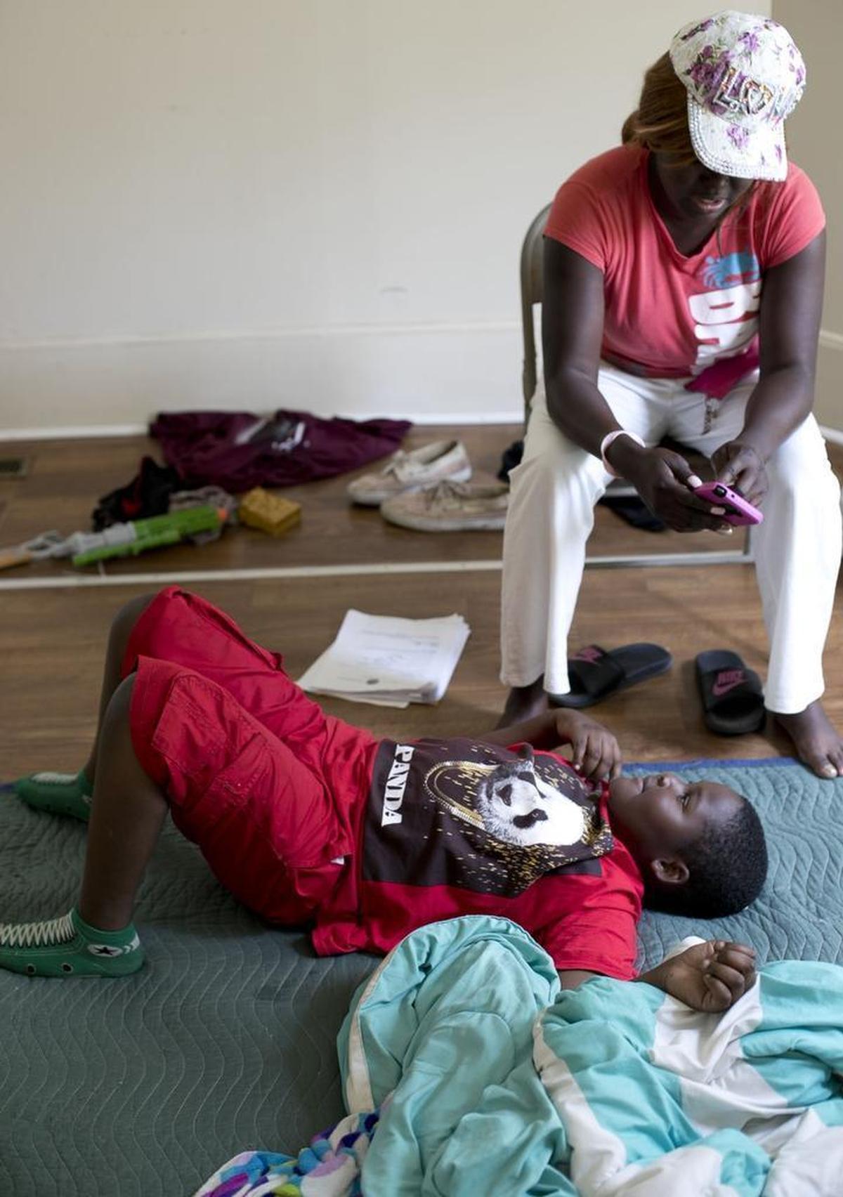 Patrice Johnson talks Thursday with her 8-year-old son Mekhai Jones in the bedroom of the rental home they moved into on Wednesday in Lumberton. They have little furniture yet, so they must sleep on the floor. They were displaced from their Lumberton home in October by Hurricane Matthew. They have lived in hotels since then.
