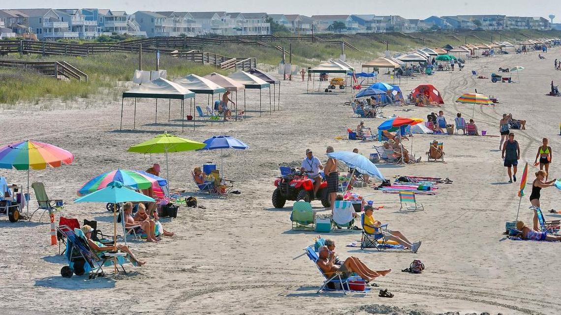 Tourist take advantage of the sand and sun at Sunset Beach, the southern most beach in North Carolina.