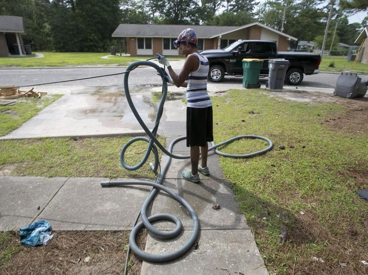 Sauconia Gerald untangles a wet vacuum after cleaning one of the homes in Weaver Court on Thursday, May 11, 2017 in Lumberton. Most of the units in the public housing neighborhood were damaged by flood waters from Hurricane Matthew in October 2016.