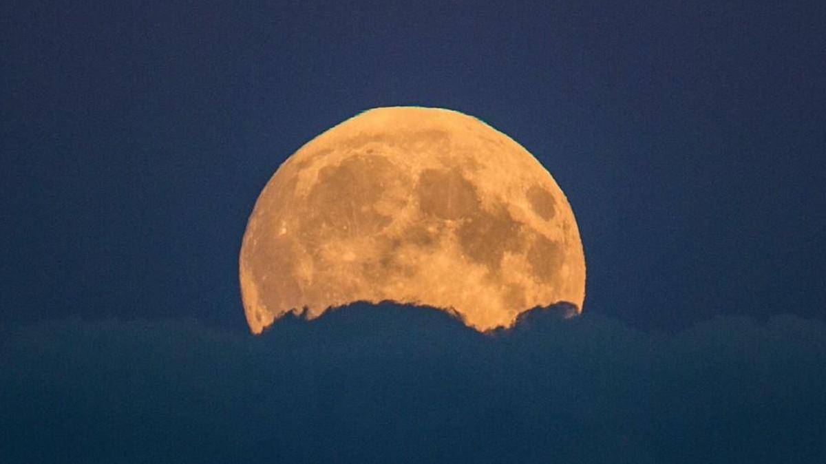 A full moon rises between clouds in Berlin, Germany, Sunday, Sept. 27, 2015.