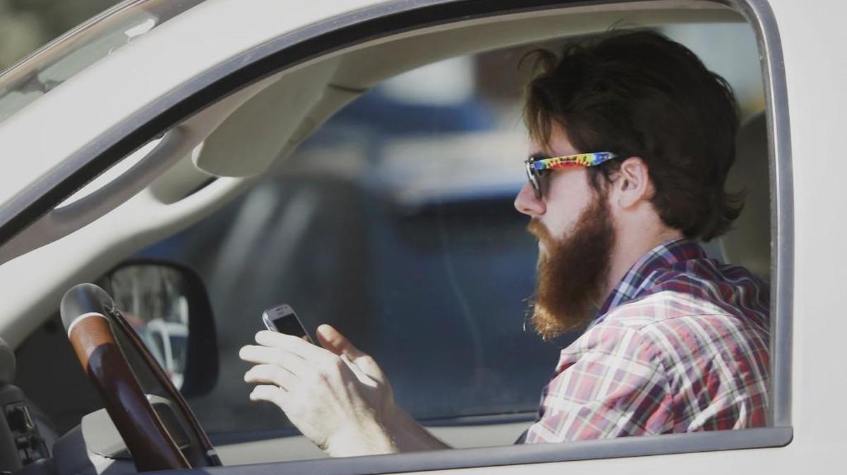 A man works his phone as he drives through traffic in Dallas in this file photo from 2013. The Travelers Companies launched a campaign against distracted driving on Monday, Nov. 6, with a symposium at N.C. State University.