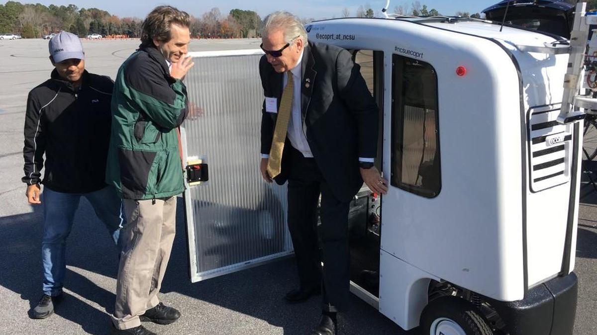 N.C. State University engineering professor Seth Hollar holds the door while Rep. John Torbett of Gaston County emerges from the EcoPRT, an autonomous vehicle developed by students and faculty at NCSU. Torbett was one of several legislators who got a first-hand look at the latest in self-driving technology at the State Highway Patrol test track in Raleigh on Monday, Dec. 4, 2017.