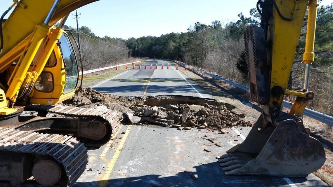 An excavator frames a five foot deep by 20-foot wide sinkhole on Tuesday, Jan. 19, 2016. The sinkhole opened up the day before across the eastbound lane of Lystra Road between Farrington Road and Jack Bennett Road in northern Chatham county forcing NC DOT to close the popular connector road between Farrington Road and Highway 15-501. A Chatham DOT road crew was also dispatched Tuesday morning to a reported second sinkhole opening across Jones Ferry Road near River Road a few miles to the west of the Lystra Road sinkhole.