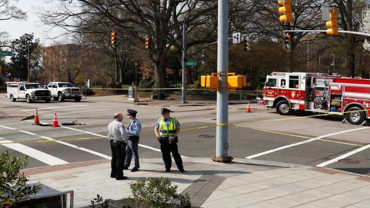 Raleigh Police and a Wake Sheriff's deputy stand at the blocked off intersection of Martin and McDowell Streets Wednesday afternoon, March 16, 2106, after an underground utility incident in which the workers evacuated their underground work space. Raleigh Police blocked off McDowell and Martin Streets for a block in all directions redirecting downtown traffic until the men could go back underground and solve the emergency situation.