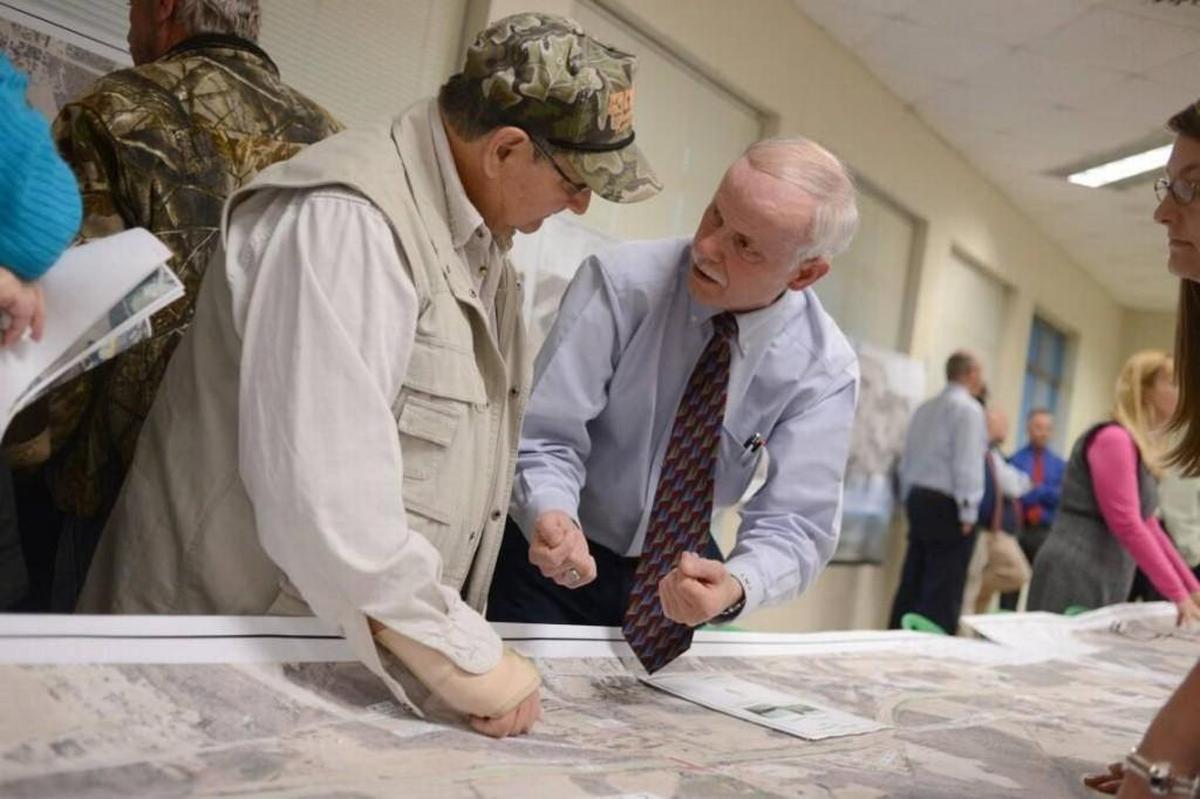 Wilson’s Mills councilman Kenneth Jones, left, stands to lost a good chunk of land as DOT turns stoplights into interchanges along U.S. 70. Jones talks with an DOT engineer during a public meeting in 2016. Another public meeting will be held Monday, July 17, at Wilson’s Mills Elementary School.