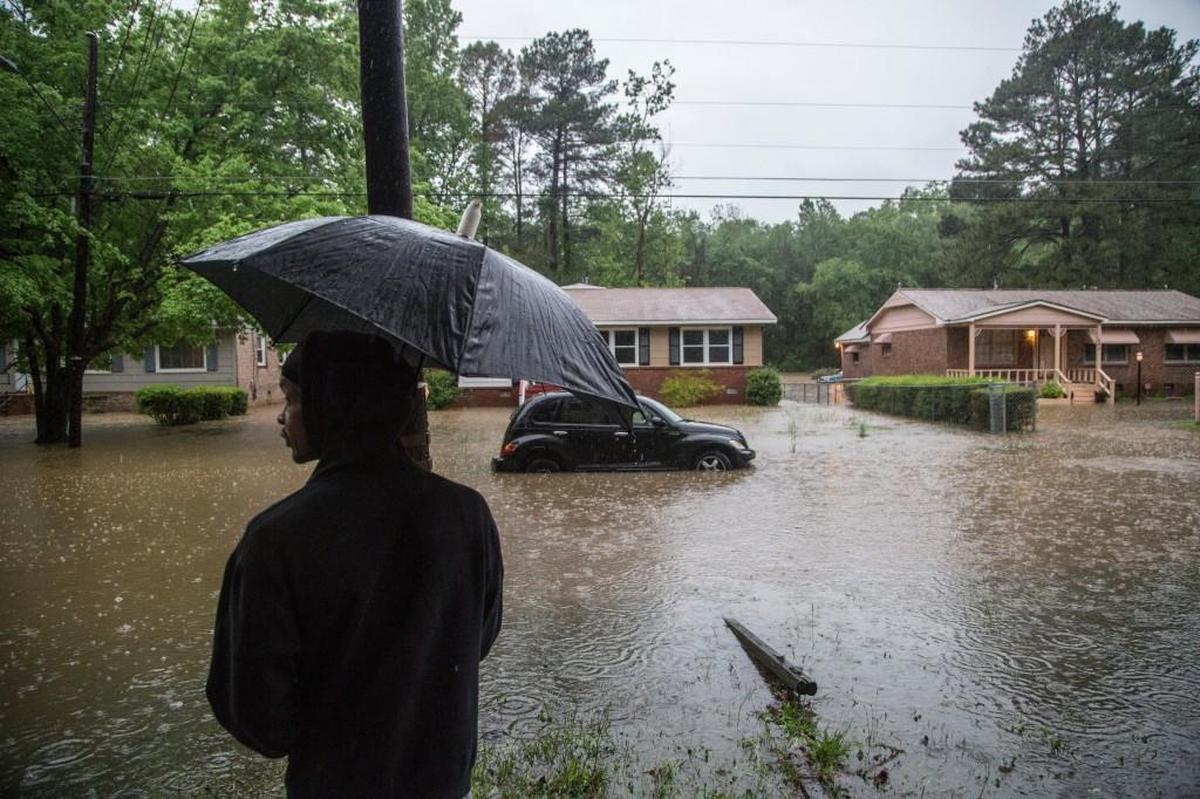Joel Jenkins watches floodwaters rise on Dacian Road in Raleigh Tuesday, April 25, 2017.