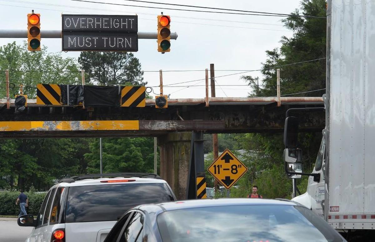 An over-height truck sets off a traffic signal that warns too-tall trucks before they go under what was then the 11-foot-8-inch tall railroad bridge over Gregson Street in this photo from May 2016.