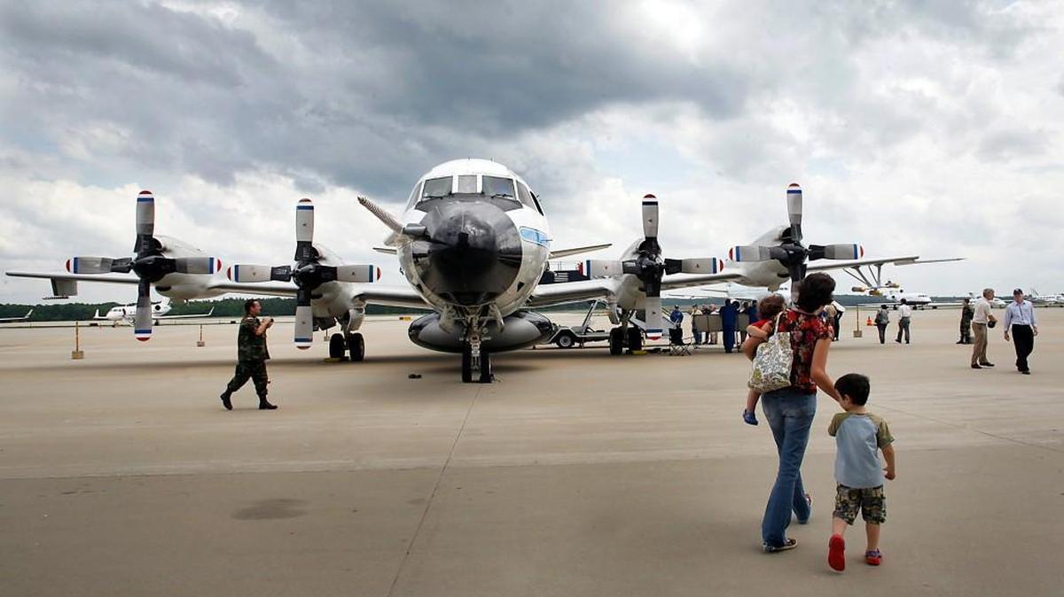 Kimberly Ballard of Apex walks her children, Alex, 1, and Ian, 4, to tour the P3 Orion Hurricane Hunter aircraft, on display at RDU International Airport on Wednesday, May 6, 2009. Staff photo by Ted Richardson/The News & Observer