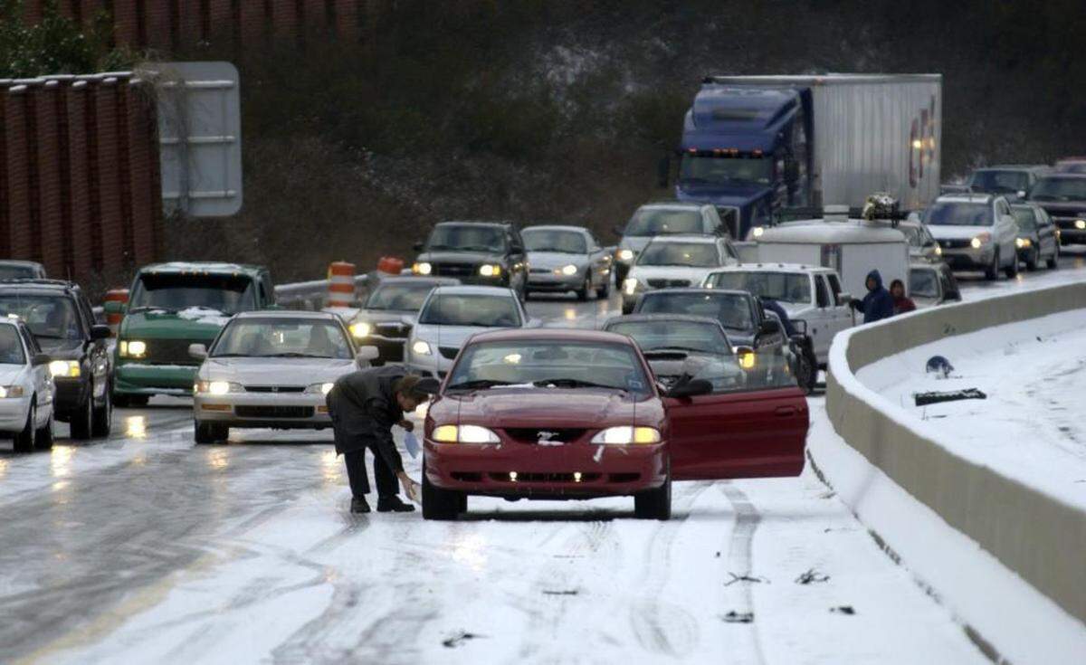 Chris Roseman from Fuquay-Varina tries to get un-stuck after his car spun out on the ice on the Outer Beltline between Lake Boone Trail and Wade Ave in Raleigh in Jan. 2005. The Triangle was taken by a surprise winter storm, closing schools, icing roads and causing traffic problems.