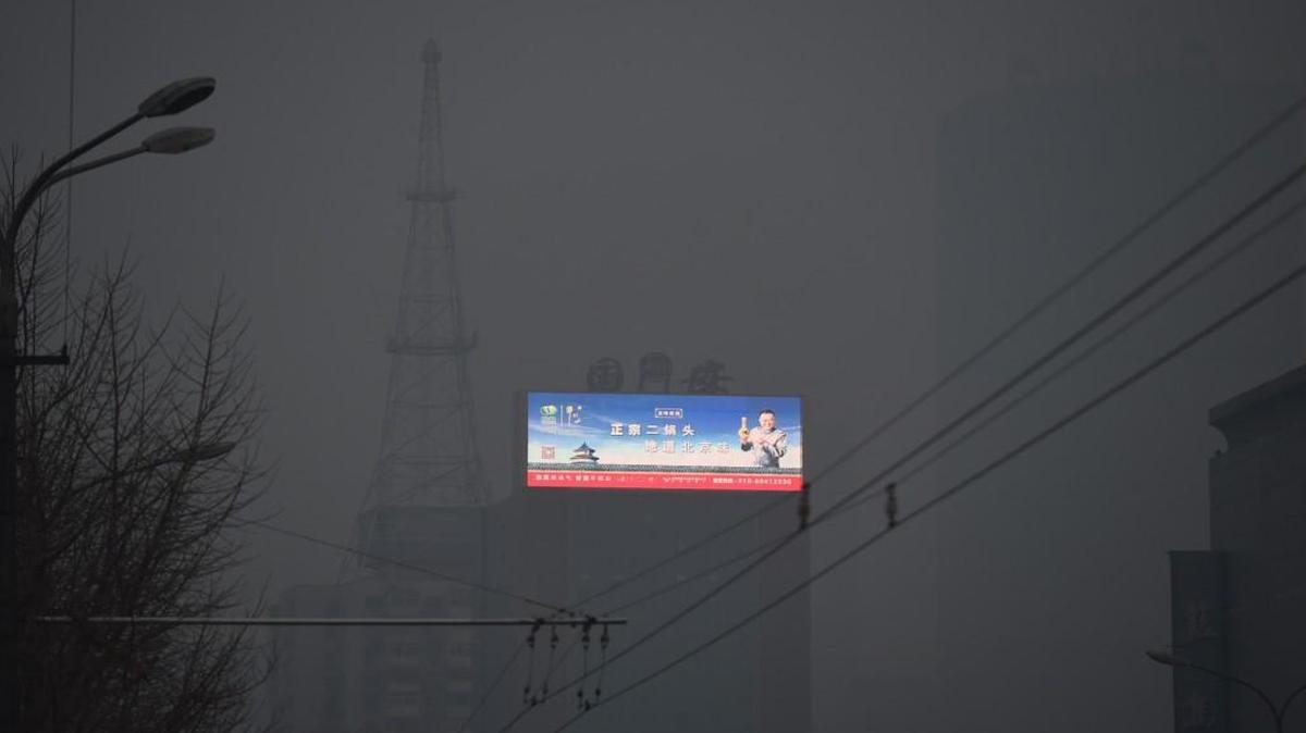 A scene of blue skies over the Temple of Heaven is seen on an electronic billboard through pollution in Beijing on November 27, 2015. China is the world's largest polluter and will be a key player at next week's climate change talks in Paris in the face of disputes over whether developed or developing countries should bear more of the burden for reducing emissions.