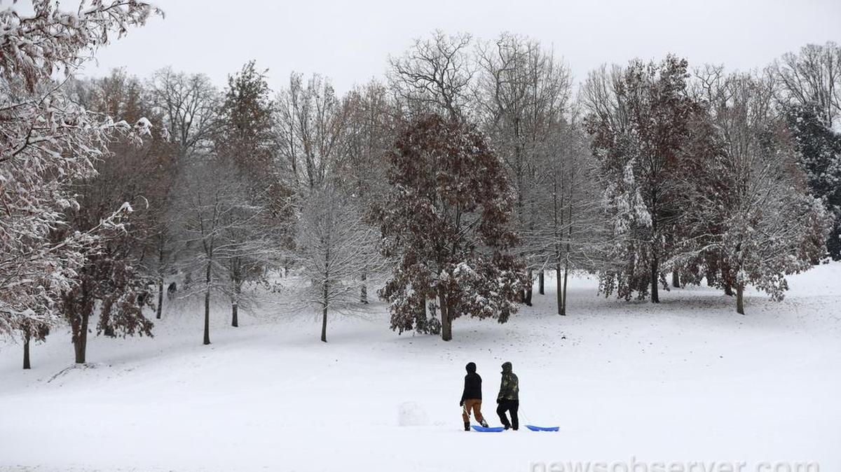 Sledders walk through Dorothea Dix park in Raleigh Sunday morning, Dec. 9, 2018.