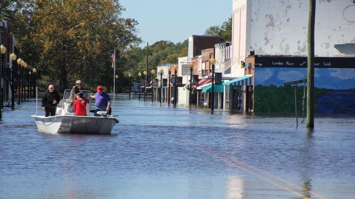 Allen Thompson navigates a boat down flooded Main Street in Fair Bluff, NC after Hurricane Matthew dumped heavy rains on North Carolina.