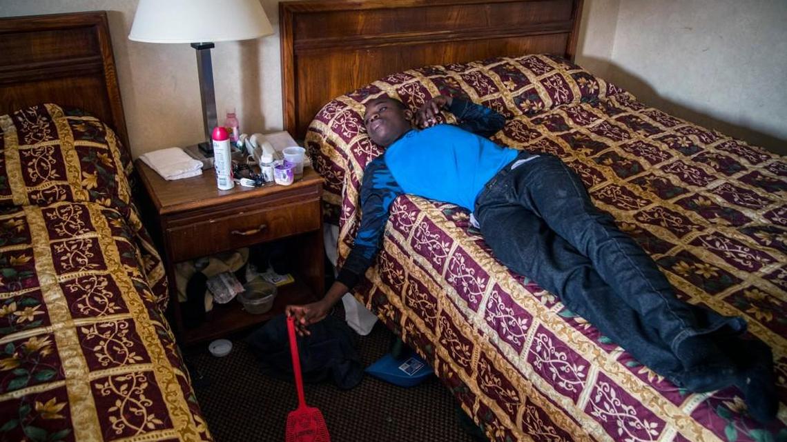 Displaced by flooding from Hurricane Matthew, 14-year-old Kevin Greene lies on a bed Wednesday Nov. 23, 2016 at a Days Inn motel in Goldsboro. His family has been living in the motel for two weeks, unsure when they will be able to return to their home.