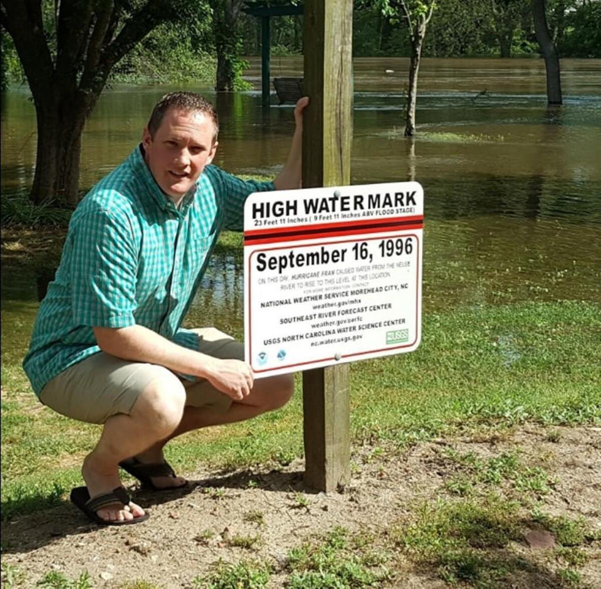 Kinston Mayor B.J. Murphy poses near a sign marking where flooding from the Neuse River reached in 1996 during Hurricane Fran. The river is expected to reach that level again Wednesday.