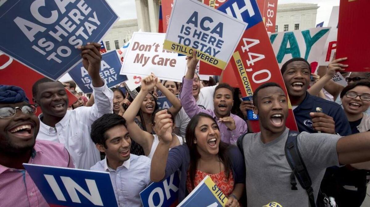 Students outside of the Supreme Court in Washington cheer as they hold up signs supporting the Affordable Care Act (ACA) after the Supreme Court decided that the ACA may provide nationwide tax subsidies on June 25, 2015.