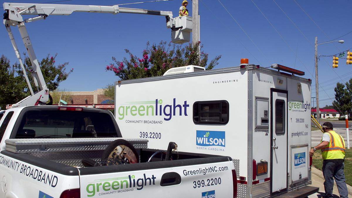 Greenlight Community Broadband employee Chris Hedrick (in bucket) installs a fiber optic unit on Forest Hills Road in Wilson in 2014. State policy has made it difficult for other local governments to set up similar systems in underserved rural areas.
