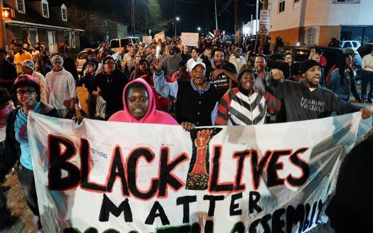 The crowd marches down Bragg Street to the Bible Way Temple after speakers memorialized shooting victim Akiel Denkins in Raleigh.