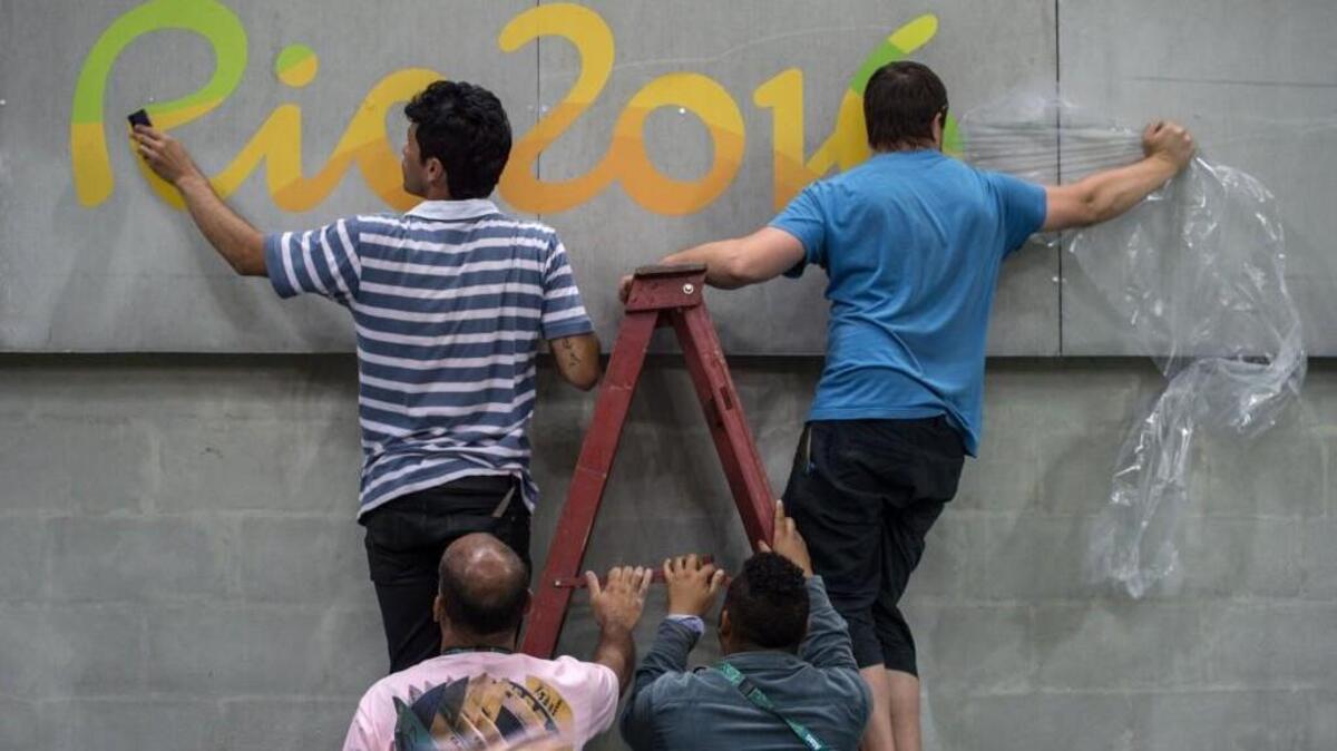 Workers install a Rio 2016 logo at the Riocentro venue in Rio de Janeiro on Thursday ahead of the Rio 2016 Olympic Games.