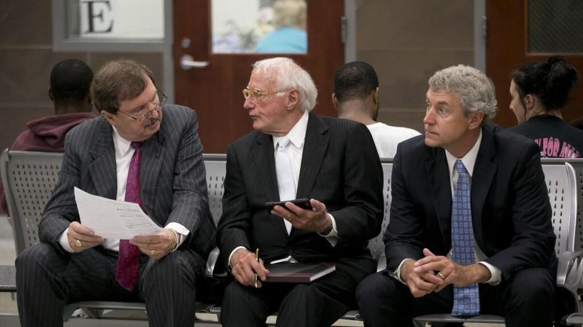 Sen. Fletcher Hartsell, left, confers with attorneys Wade Smith, center, and Roger Smith as they wait to appear before a magistrate at the Wake County Detention Center on Tuesday in Raleigh, N.C. Hartsell was indicted by the Wake County grand jury on allegations that he signed false campaign finance reports.