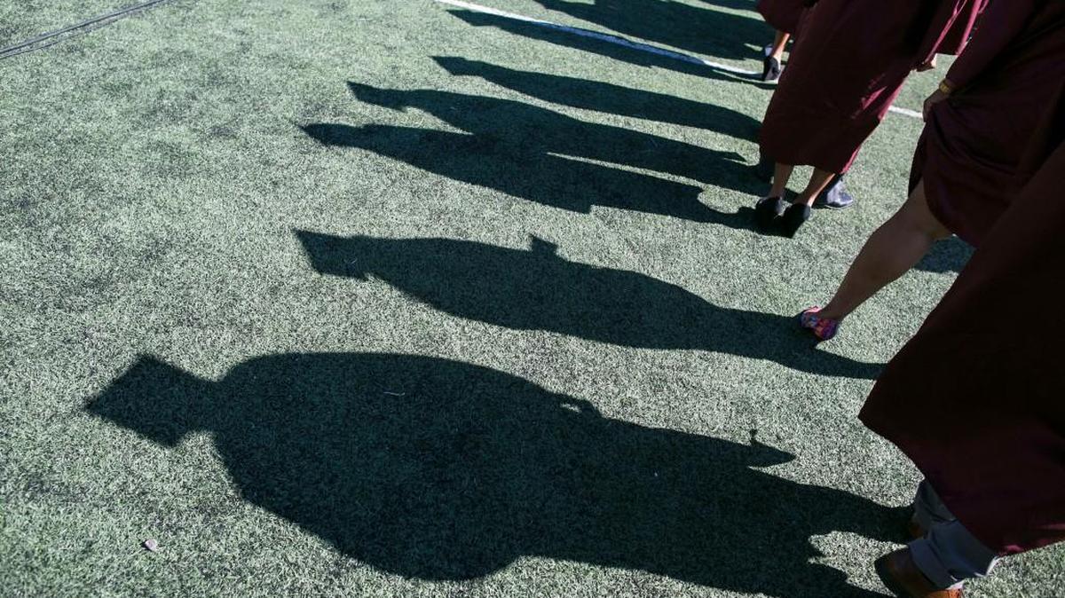 Shadows of graduates donning various elaborate shoes are seen during the 127th Commencement Exercises at North Carolina Central University in Durham, N.C., Saturday, May 14, 2016.