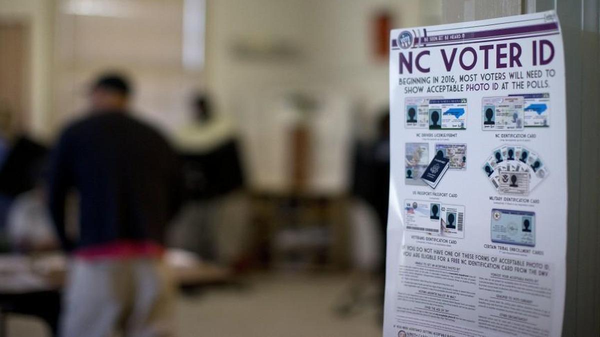 This photo taken March 15, 2016, shows a NC Voter ID rules posted at the door of the voting station at the Alamance Fire Station in Greensboro. A federal appeals court on Friday blocked a North Carolina law that required voters to produce photo identification and follow other rules disproportionately affecting minorities, finding that the law was intended to make it harder for blacks to vote in the presidential battleground state.