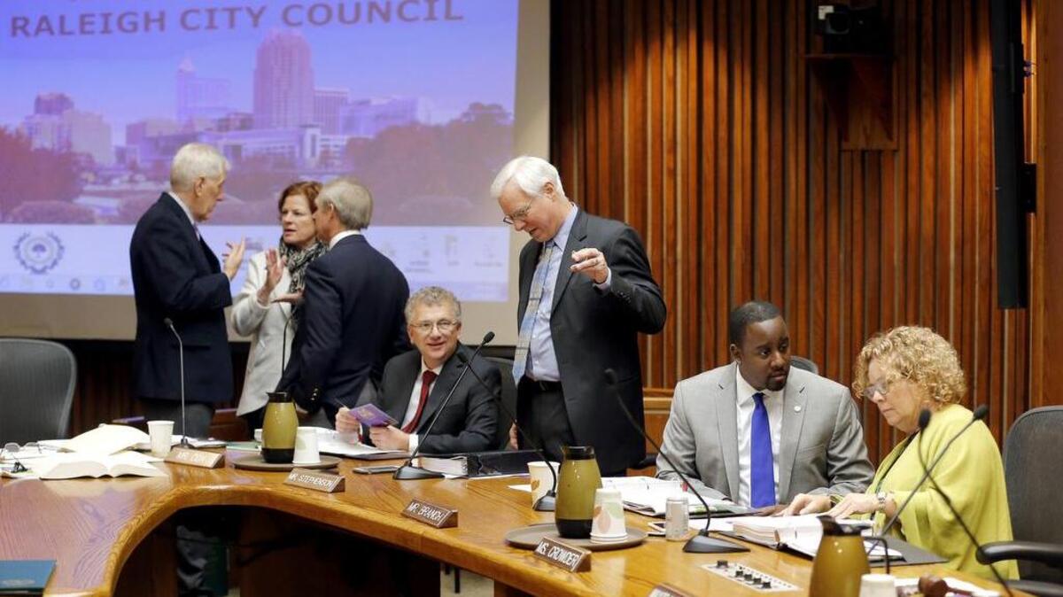From left, Raleigh city attorney Thomas McCormick, council members Mary-Ann Baldwin, Dickie Thompson, David Cox, Russ Stephenson, Corey Branch and Kay Crowder socialize before the Raleigh City Council meets in its chambers in downtown Raleigh on Dec. 1, 2015.