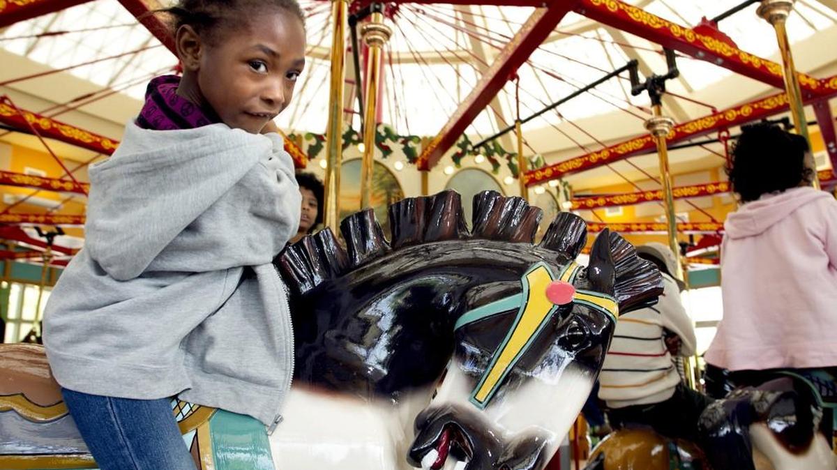 Five-year-old Danicka Kennedy of Raleigh, N.C. enjoys a ride on the Allan Herschell Carousel inside the new carousel house following it's dedication at Chavis Park on Saturday April 20, 2013 in Raleigh.