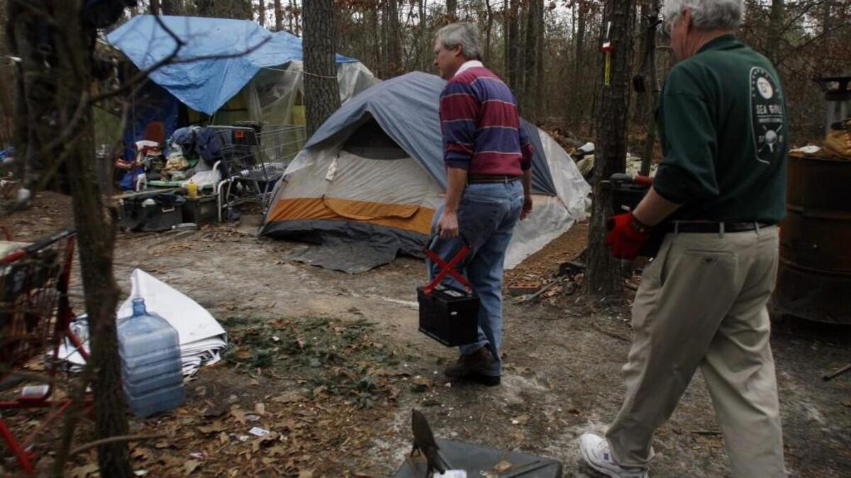 Dan, center, and Harry Walker deliver supplies to a homeless camp in Raleigh with The Church In The Woods, a Christian charitable organization supporting those in the local homeless community. Wake County Commissioner Matt Calabria is pushing for more housing for the homeless. (Photo by Ray Black III