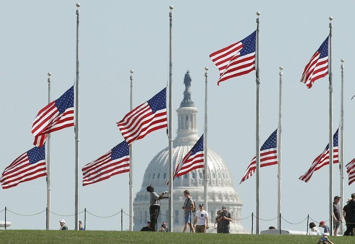 A Park Service employee lowers the U.S. flags on the grounds of the Washington Monument to half-staff, on October 2, 2017 in Washington, DC. President Donald Trump ordered the flags on all federal buildings to fly at half-staff following the mass shooting that left more than 50 dead in Las Vegas. (Photo by Mark Wilson/Getty Images)