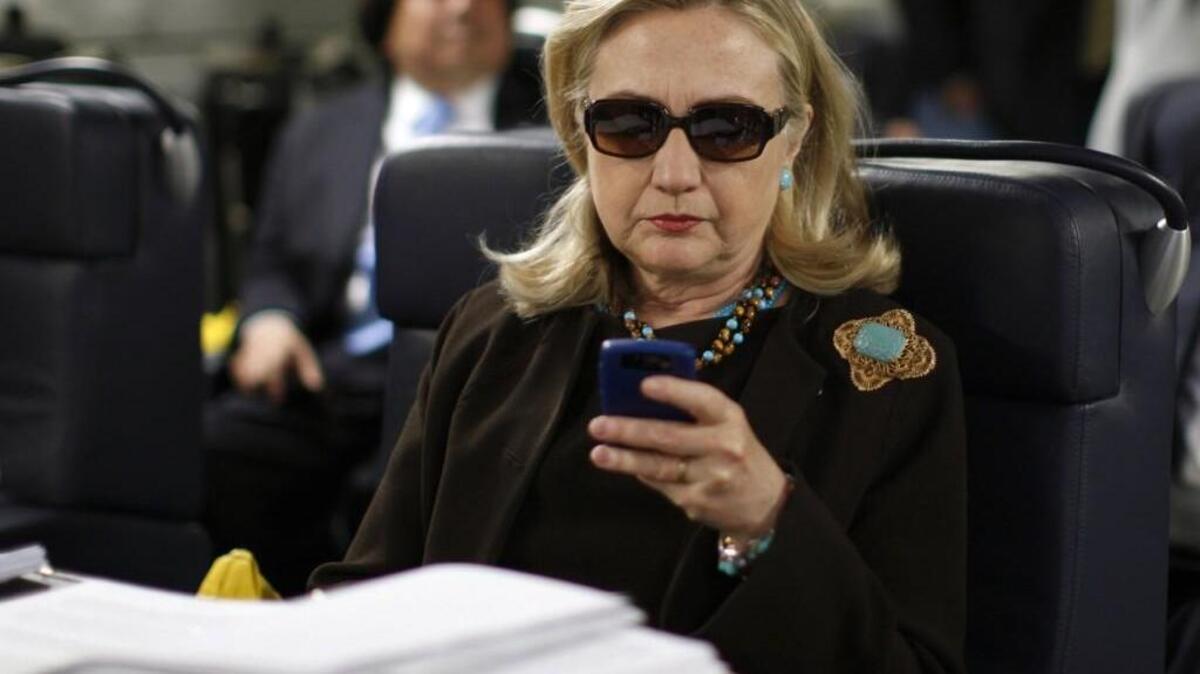 Then-Secretary of State Hillary Rodham Clinton checks her Blackberry from a desk inside a C-17 military plane upon her departure from Malta, in the Mediterranean Sea in 2011. The FBI found her use of a private server for official business was careless, but not criminal.