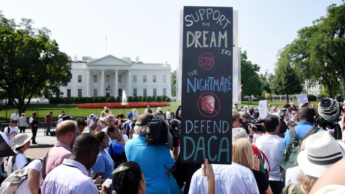 Protesters hold up signs during a rally supporting Deferred Action for Childhood Arrivals, or DACA, outside the White House on September 5, 2017. Despite months of calls from members of both parties to reach a deal before the end of the year, lawmakers are likely to head home for the holidays without a solution for the 800,000 people who were brought here illegally by their parents at a young age.