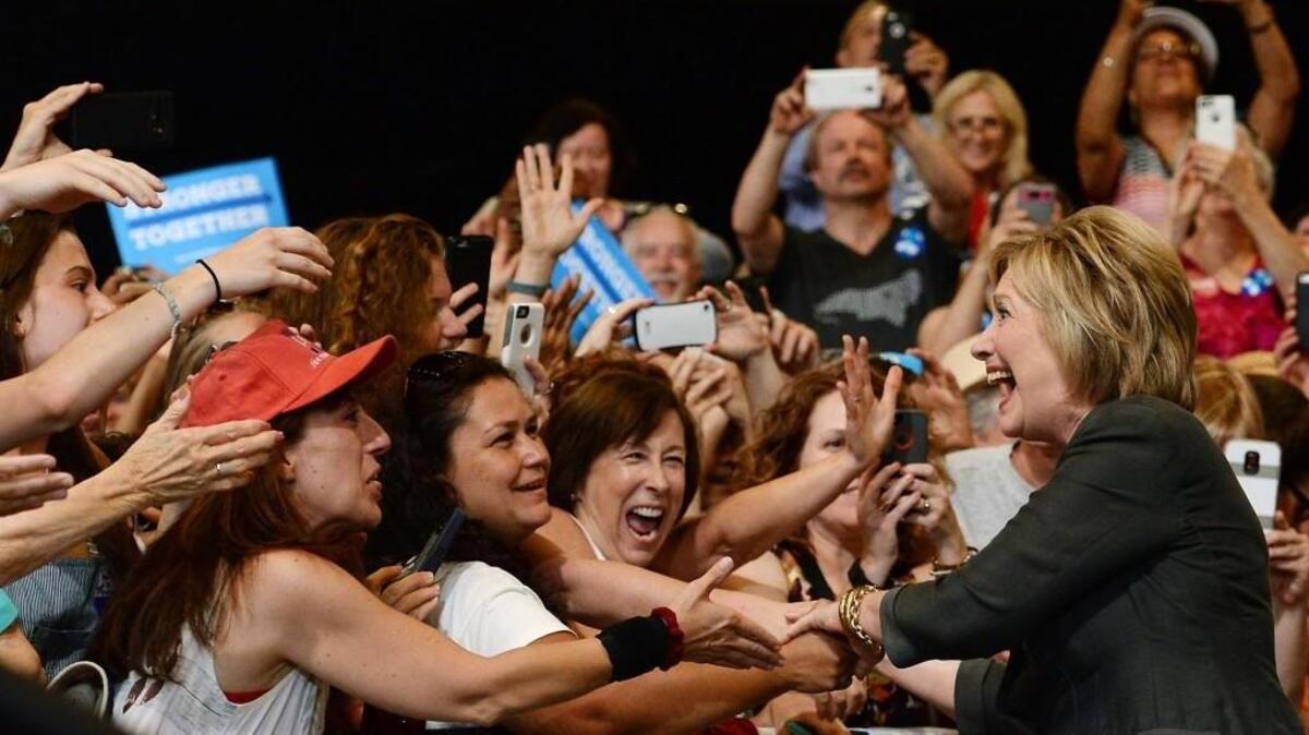 Democratic presidential hopeful Hillary Clinton gets a warm greeting from the crowd as she enters the Exposition Center of the North Carolina State Fairgrounds in Raleigh on June 22.