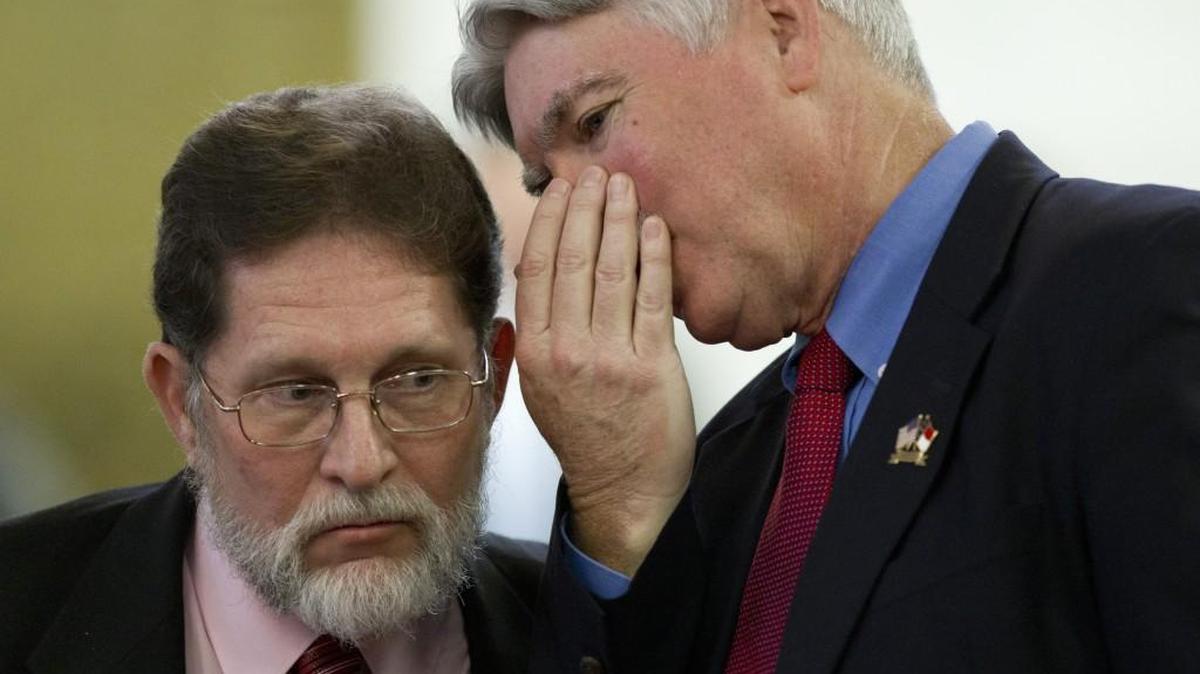 Reps. Larry Pittman (Rep), left, and Jeff Collins (Rep) confer as the N.C. House debated a bill at the Legislative Building in Raleigh on August 19, 2014.