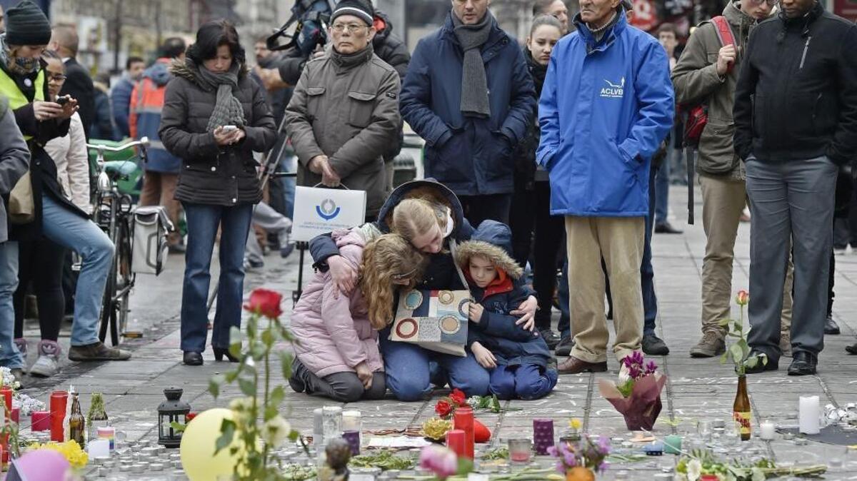 People mourn for the victims of the bombings at the Place de la Bourse in the center of Brussels on March 23, 2016. Bombs exploded March 22 at the Brussels airport and one of the city's metro stations, killing and wounding scores of people.