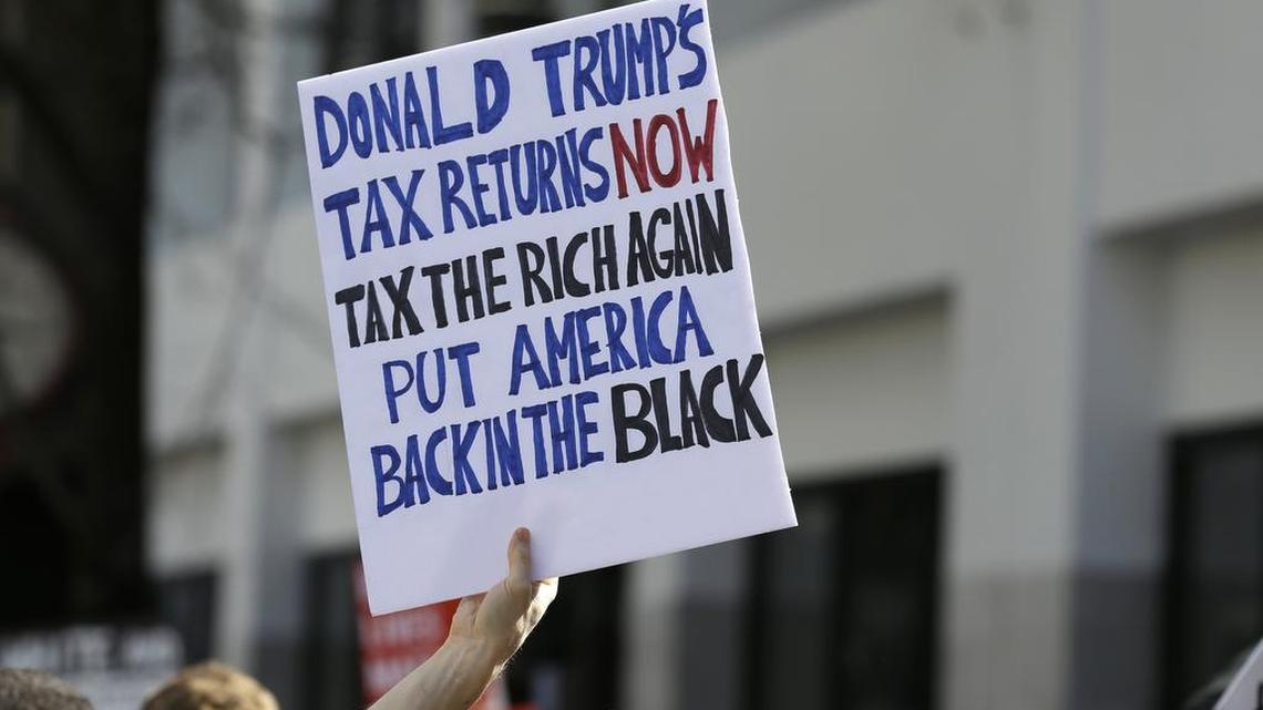 A person in Seattle holds a sign during a rally Saturday, April 15, 2017 that calls for President Donald Trump to release his tax returns so Americans can scrutinize his business ties and potential conflicts of interest. Trump was the first major-party nominee in more than 40 years not to release his tax returns, saying it was because he was under audit. Similar rallies were held in other U.S. cities as the deadline approaches for 2016 tax returns to be filed.