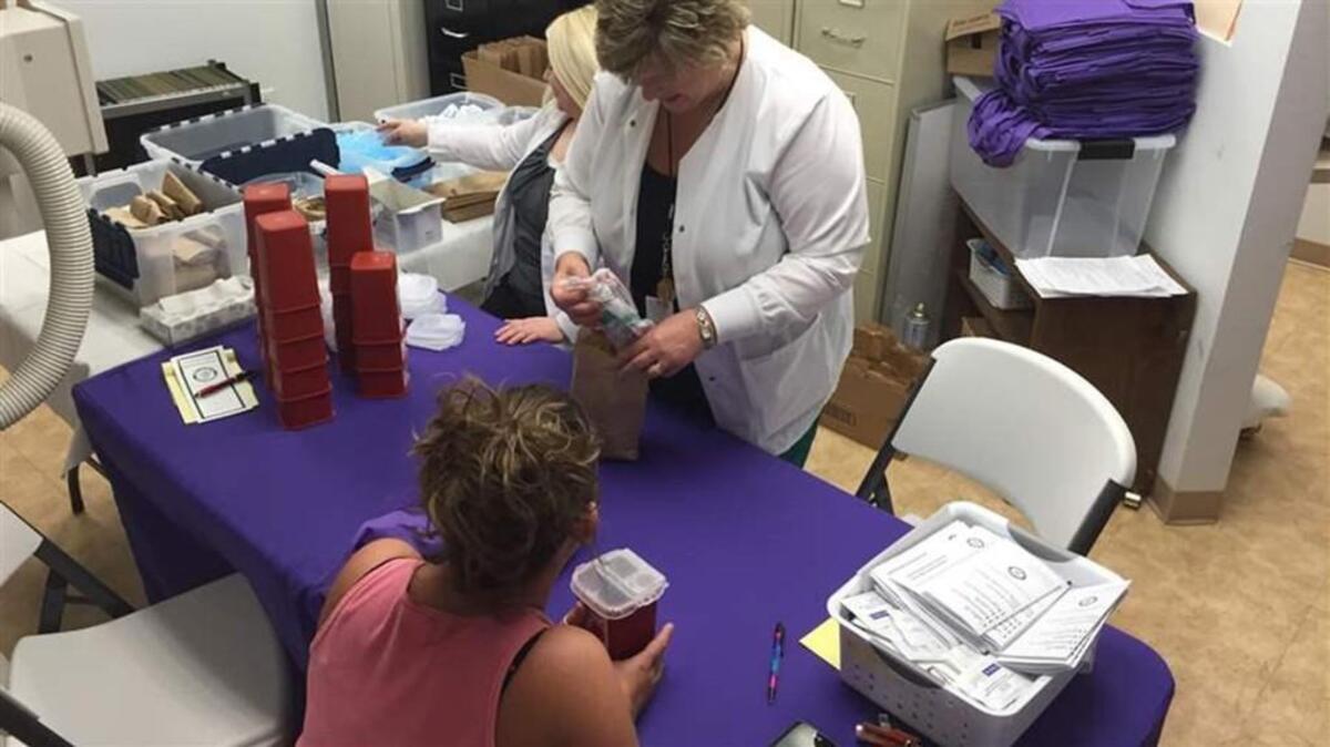 Registered Nurse Carol Simmons prepares a bag of sterile IV injection supplies - including syringes, alcohol swabs and sterile water - for Krista Spears, a patient at a needle exchange program in Huntington, West Virginia. Huntington has adopted a model intervention program to try to prevent drug overdoses.