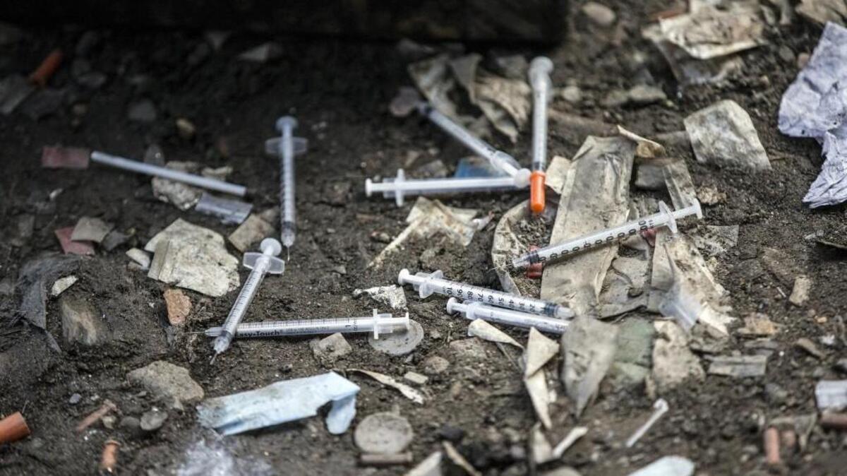 Used needles litter the ground at an open air drug market along Conrail train tracks in the Kensington section of Philadelphia. Am needle exchange program in North Carolina is helping introduce addicts to treatment programs.