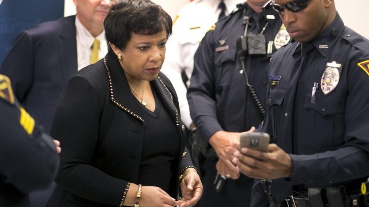 U.S. Attorney General Loretta E. Lynch gets an demonstration of a body camera, controlled by his smartphone by Fayetteville Police Officer D. Gousby on Tuesday, May 24, 2016 in Fayetteville, N.C.