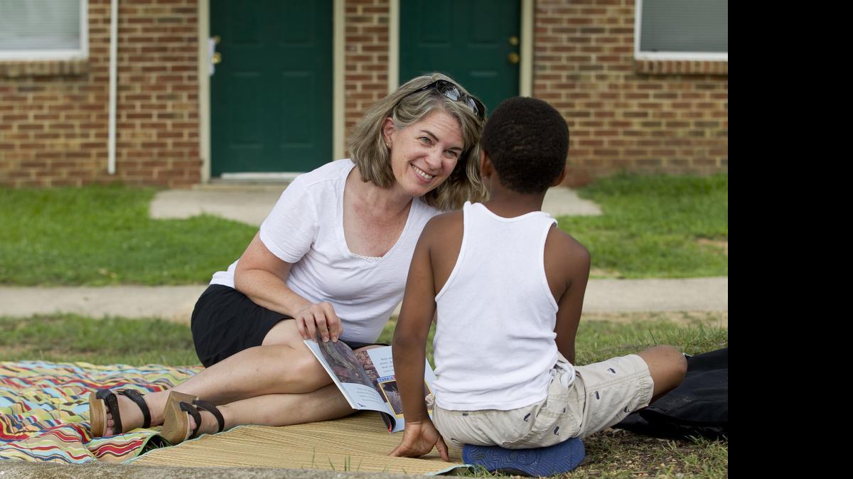 Lacy Elementary School faculty member Carol Brinkley reads with 6-year-old Michael Farley during a visit by the Lacy Bookmobile to Michael’s Raleigh neighborhood.