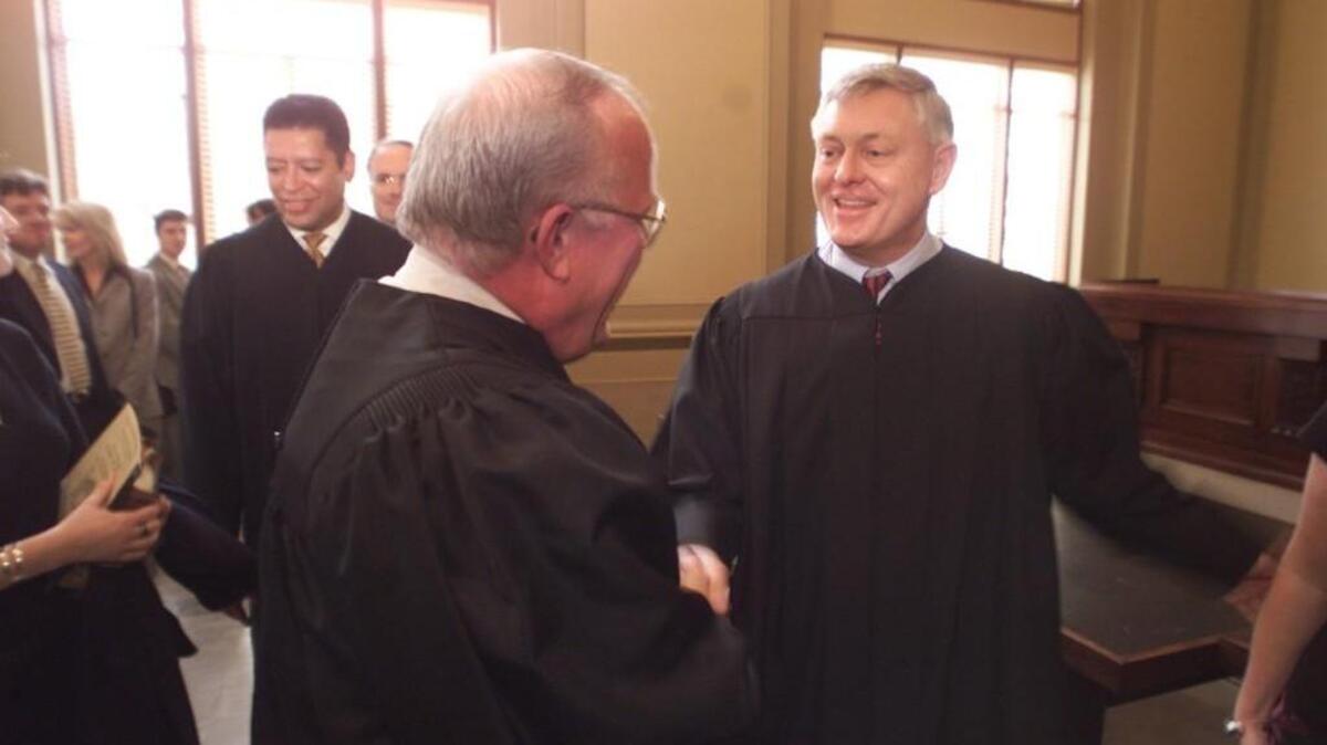 Chief Judge Sidney S. Eagles, Jr. congratulates Douglas McCullough after McCullough is sworn in as an Associate Judge of the North Carolina Court of Appeals in 2001. McCullough, a Republican, stepped down early this week to make it possible for Democratic Gov. Roy Cooper to appoint his replacement, John Arrowood.