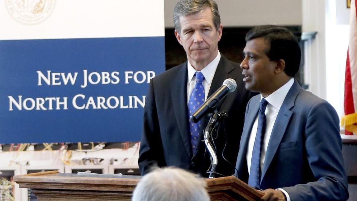 Gov. Roy Cooper, left, and Infosys president Ravi Kumar announced in 2017 that the tech expected to create 2,000 jobs in the Triangle. It acknowledged Tuesday that it would not meet that goal.